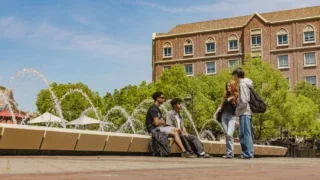 Students chatting next to a fountain.